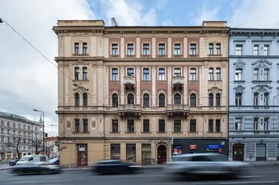 a building on a street with cars driving past it at Spectrum Apartment in Prague