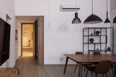 a dining room with a table and chairs and a hallway at Spectrum Apartment in Prague