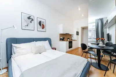 a bedroom with a bed and a table and chairs at Rentero Charles square studio apartment Parking on request in Prague