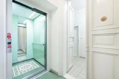 a glass door in a hallway with a tile floor at Rentero Charles square studio apartment Parking on request in Prague
