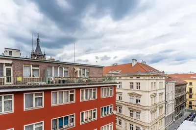 a group of buildings in a city under a cloudy sky at Rentero Charles square studio apartment Parking on request in Prague