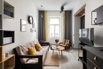 a living room with a couch and a tv at Urban Wave Apartment in Prague