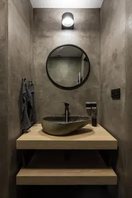 a bathroom with a sink with a round mirror at Urban Wave Apartment in Prague