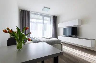 a white living room with a table and a couch at 12 min Centrum, 200Mb WIFI, Onsite Supermarket in Prague