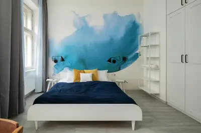 a bedroom with a bed and a blue wall at Ocean Breeze Apartment in Prague