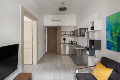 a living room with a couch and a kitchen at Ocean Breeze Apartment in Prague