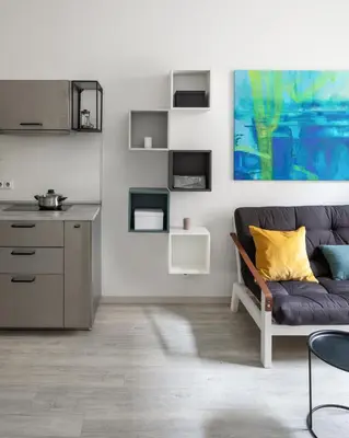 a living room with a couch and a kitchen at Ocean Breeze Apartment in Prague
