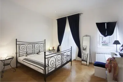 a bedroom with a black bed and a mirror at Charles Bridge Apartment in Prague