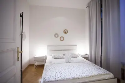 a white bedroom with a white bed and a door at Charles Bridge Apartment in Prague