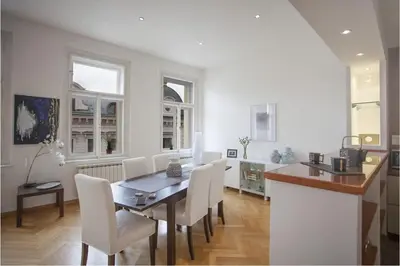 a dining room with a table and white chairs at Charles Bridge Apartment in Prague