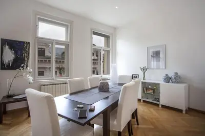 a dining room with a table and white chairs at Charles Bridge Apartment in Prague