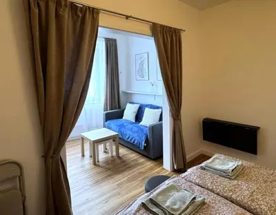a room with two beds and a blue couch at Short Way Apartments in Prague