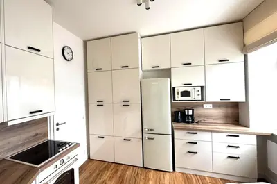 a kitchen with white cabinets and a refrigerator at Short Way Apartments in Prague