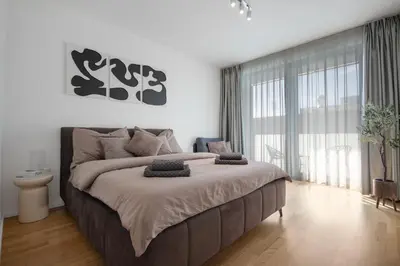a bedroom with a large bed and a large window at Viktoria Suite N3 with Garage & Balcony in Prague