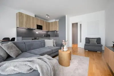 a living room with a gray couch and a table at Viktoria Suite N3 with Garage & Balcony in Prague