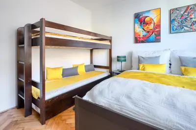 a bedroom with two bunk beds with yellow pillows at Apartmán Flora in Prague