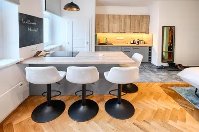 a kitchen with a large wooden table with four stools at Apartmán Flora in Prague