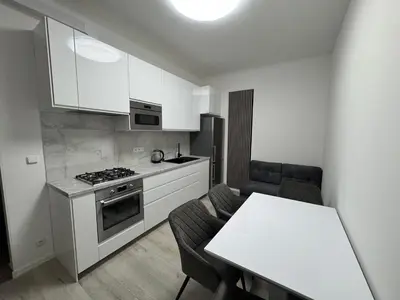a kitchen with white cabinets and a table and a stove at Modern, comfortable apartments near the metro in Prague