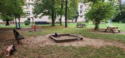 a child sitting in a sandbox in a park at Modern, comfortable apartments near the metro in Prague