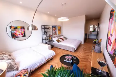 a living room with two beds and a table at Sunny & Quiet studio in peaceful hood,metro access in Prague