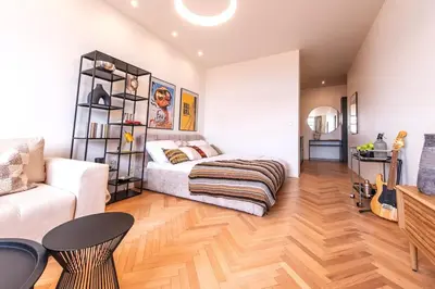 a bedroom with a bed and a living room at Sunny & Quiet studio in peaceful hood,metro access in Prague