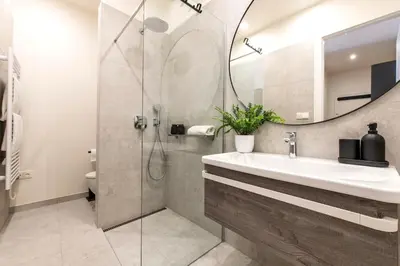 a bathroom with a sink and a shower with a mirror at Sunny & Quiet studio in peaceful hood,metro access in Prague