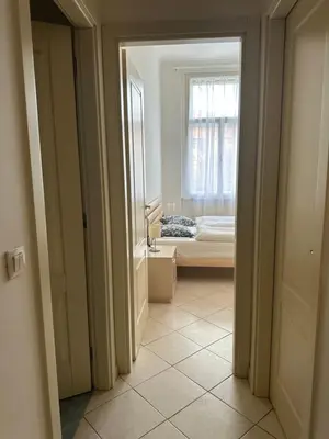a hallway with a room with a bed and a window at Tyrsova Apartment City Centre in Prague