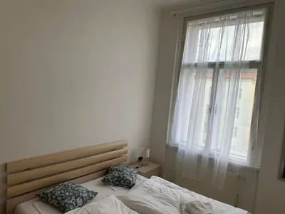 a bedroom with a bed with two pillows and a window at Tyrsova Apartment City Centre in Prague