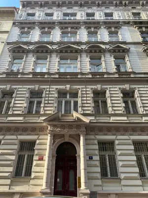 a large white building with a red door at Tyrsova Apartment City Centre in Prague