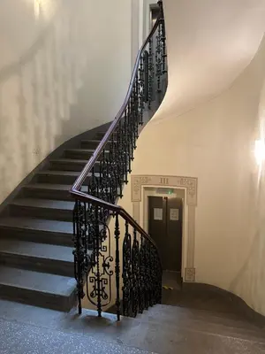 a spiral staircase in a building with a black door at Tyrsova Apartment City Centre in Prague