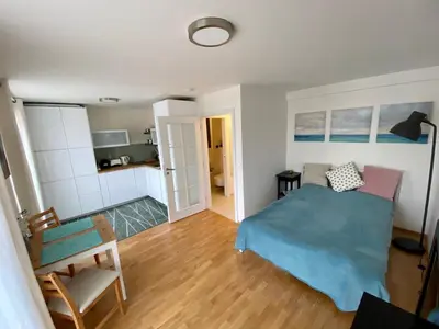 a bedroom with a blue bed and a kitchen at Apartment with a terrace and AC in the city center in Prague