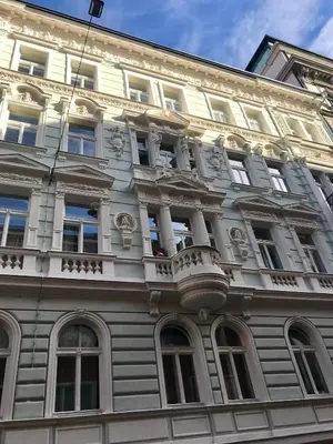 a white building with a balcony on the side of it at Apartment with a terrace and AC in the city center in Prague