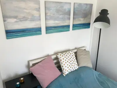 a bedroom with three paintings on the wall and a bed with pillows at Apartment with a terrace and AC in the city center in Prague