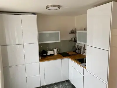 a kitchen with white cabinets and a counter top at Apartment with a terrace and AC in the city center in Prague
