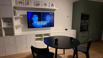 a kitchen with a table and a tv on a wall at NEW STYLISH APARTMENT Varta Alpha 2025 & Parking in Prague
