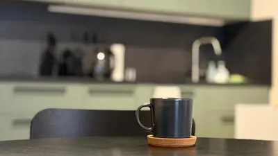 a coffee cup sitting on a table in a kitchen at NEW STYLISH APARTMENT Varta Alpha 2025 & Parking in Prague
