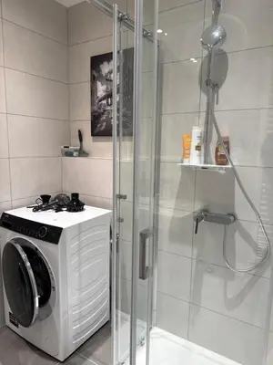a bathroom with a washing machine and a shower at NEW STYLISH APARTMENT Varta Alpha 2025 & Parking in Prague