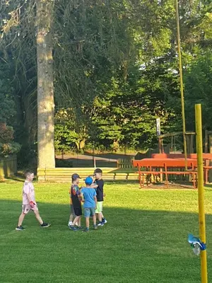 a group of children standing in the grass at U dobroty in Nový Dŭm