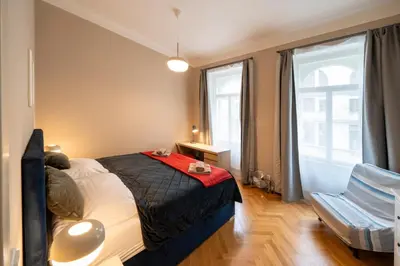 a bedroom with a bed and a chair and a window at 1 Bed Flat - Sleeps 5 - Parking - Wifi in Prague