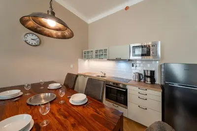 a kitchen with a wooden table and a black refrigerator at 1 Bed Flat - Sleeps 5 - Parking - Wifi in Prague