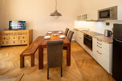 a kitchen with a wooden table and chairs in a kitchen at 1 Bed Flat - Sleeps 5 - Parking - Wifi in Prague
