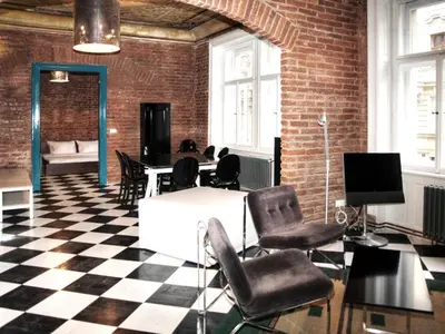 a room with a table and chairs and a brick wall at 2 Bed Flat - Sleeps 3 - Wifi in Prague