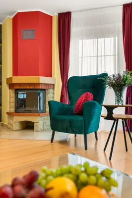 a living room with a green chair and a fireplace at Villa Garden & Terrace Villa by Interhome in Prague
