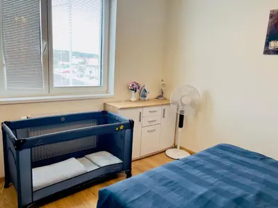 a bedroom with a blue crib and a window at Tomaš Apartment,Free Parking-02 Arena in Prague