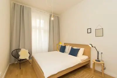 a bedroom with a bed and a chair and a window at Modern apartment with garden in Prague