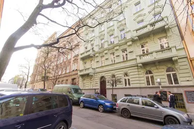 a large building with cars parked in front of it at Modern apartment with garden in Prague