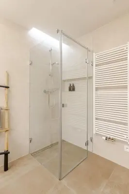a shower with a glass door in a bathroom at Modern apartment with garden in Prague