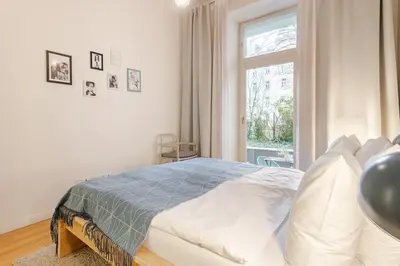 a white bedroom with a bed and a window at Modern apartment with garden in Prague