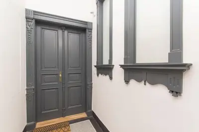 a hallway with a gray door and a mirror at Modern apartment with garden in Prague