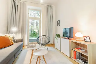 a living room with a couch and a tv at Modern apartment with garden in Prague